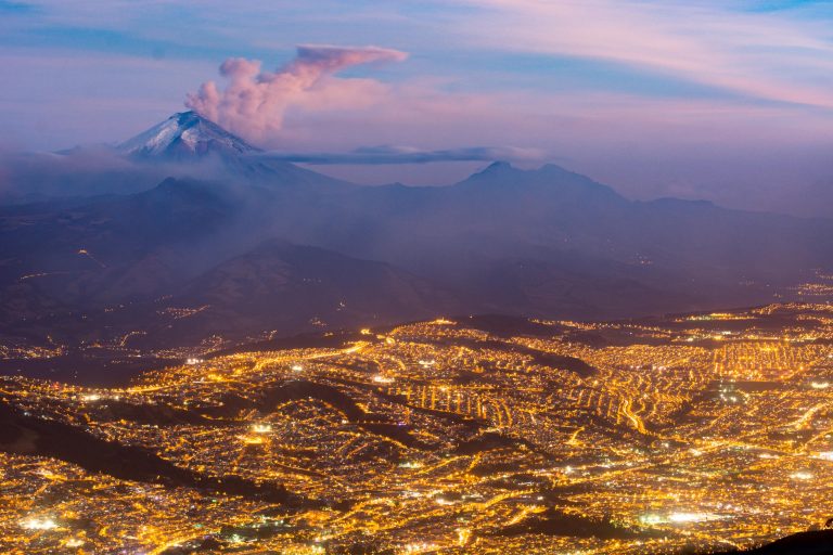La ville de Quito à la tombée de la nuit avec le Cotopaxi en éruption dans le fond, Equateur - Arrivée en Équateur - Quito - Endémiques de Darwin avec Birding Experience